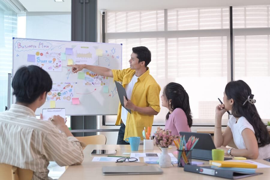 Palabras clave en wordpress cómo elegir - Presentación en equipo con un pizarrón lleno de ideas