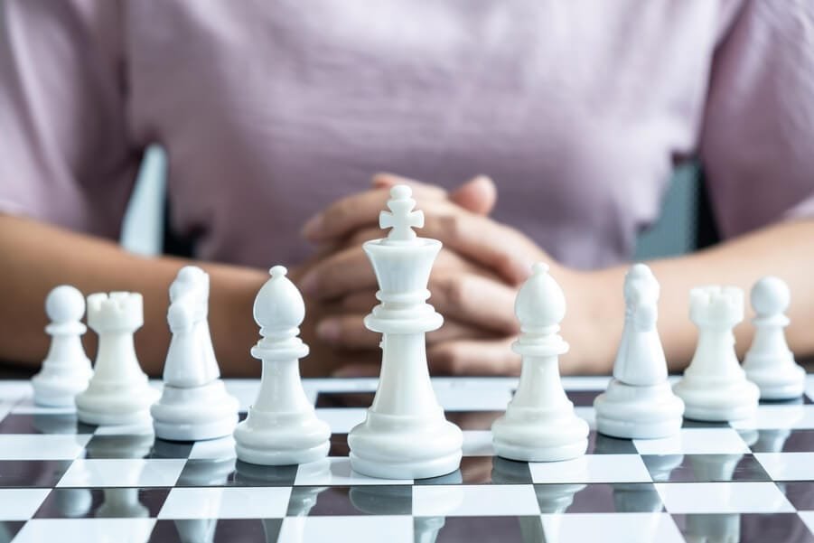 Que es tráfico orgánico en marketing estrategias para aumentar - Persona reflexionando estratégicamente frente a un tablero de ajedrez con piezas blancas.